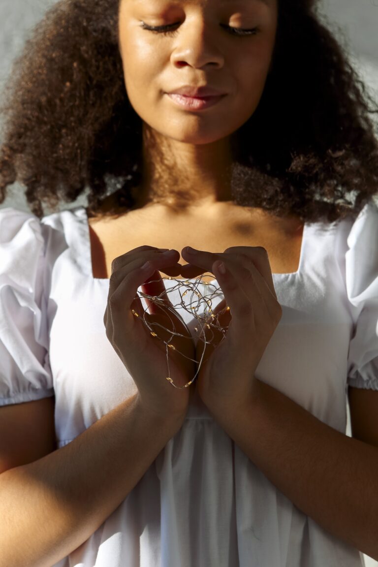 Led lights in hands of young peaceful grateful thankful african american woman making heart sign