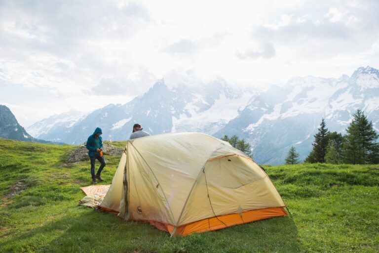 Two campers setting up a tent in the Alps
