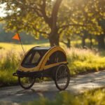 Fahrradanhänger für Kinder mit Wimpel hinter einem Fahrrad auf einem Radweg im Grünen