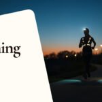 Läuferin mit Stirnlampe und reflektierender Weste joggt in der Abenddämmerung