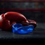 Sport-Mundschutz liegt neben Boxhandschuhen auf einer Trainingsbank im Kampfsport-Gym