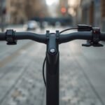 Moderner grauer E-Scooter auf einem Gehweg, Nahaufnahme von Lenkervorbau und Rahmen-Verbindungsstelle