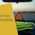 Gelbe Warnweste auf dem Armaturenbrett eines Autos, im Hintergrund ein Warndreieck auf der Straße