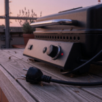 Schwarzer Elektrogrill auf einer Terrasse mit gezogenem Netzstecker als Symbol für den Char-Broil-Rückruf wegen Stromschlaggefahr