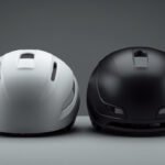 Aerodynamischer Rennradhelm und Integralhelm nebeneinander auf einer Werkbank